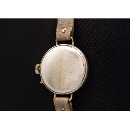 97 - An early 20th century nickel cased officer's trench wristwatch. The 28mm black dial with cream Arabi... 