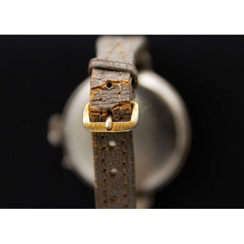 97 - An early 20th century nickel cased officer's trench wristwatch. The 28mm black dial with cream Arabi... 