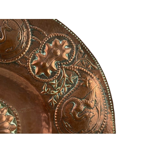 24 - An Arts and Crafts circular copper dish. John Pearson style, the copper of good gauge and repousse d... 