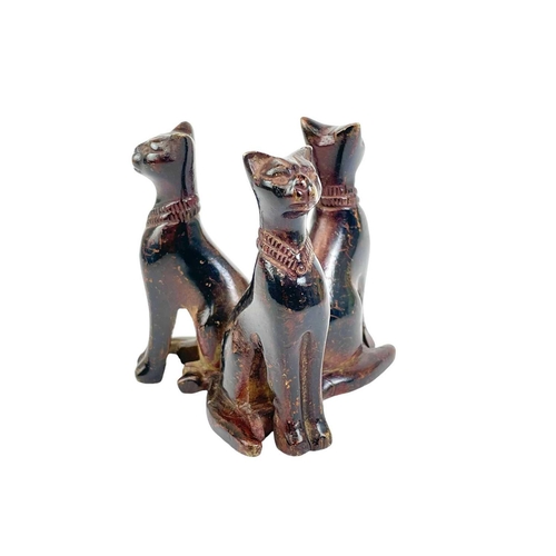 35 - An Egyptian bronze group of three cats. After the antique, late 19th/early 20th century, with a lacq... 