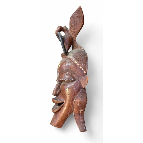 44 - A large African carved mask. Inlaid with bone, height 93cm together with another African carved mask... 