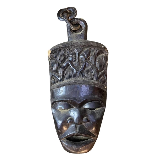 44 - A large African carved mask. Inlaid with bone, height 93cm together with another African carved mask... 