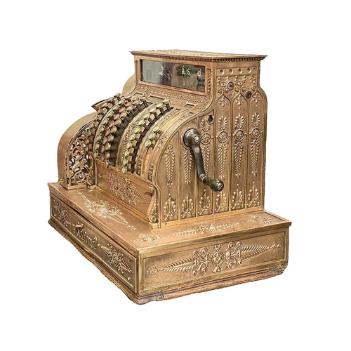 50 - A polished brass National cash register. Circa 1900, with ornate cast and pierced decoration, with c... 