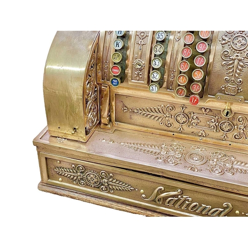 50 - A polished brass National cash register. Circa 1900, with ornate cast and pierced decoration, with c... 