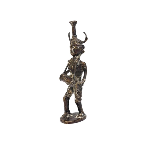 53 - An Indian cast bronze figure of a musician. Dhokra, West Bengal, the figure with a horned headpiece,... 