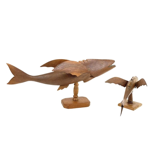 72 - A carved hardwood flying fish, stamped John Christian Pitcairn Island. Length 47cm, on a turned stan... 