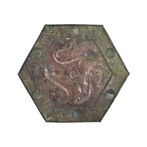 92 - An arts and crafts hexagonal copper plaque. Repousse decorated with three fish, the planished border... 