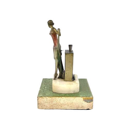 97 - An Art Deco spelter strike table lighter. Modelled as a fashionable lady, with a coloured dress and ... 