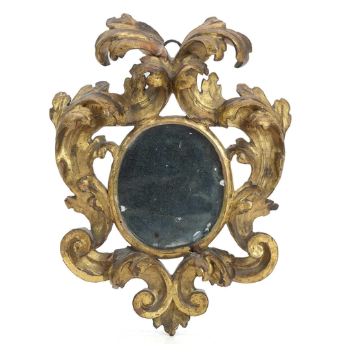 1016 - A Florentine small carved giltwood wall mirror. 18th century, with oval plate, 25X19cm. Mollie & Gra... 