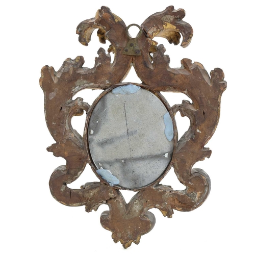 1016 - A Florentine small carved giltwood wall mirror. 18th century, with oval plate, 25X19cm. Mollie & Gra... 