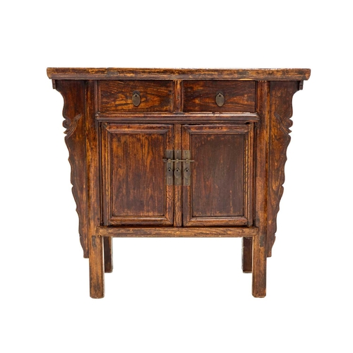 1035 - A Chinese elm side cabinet. Qing, 19th century, fitted two drawers above two doors within shaped sid... 