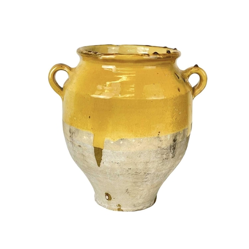 1042 - A French provincial yellow glazed pot. 19th century, with twin loop handles and unglazed lower part,... 