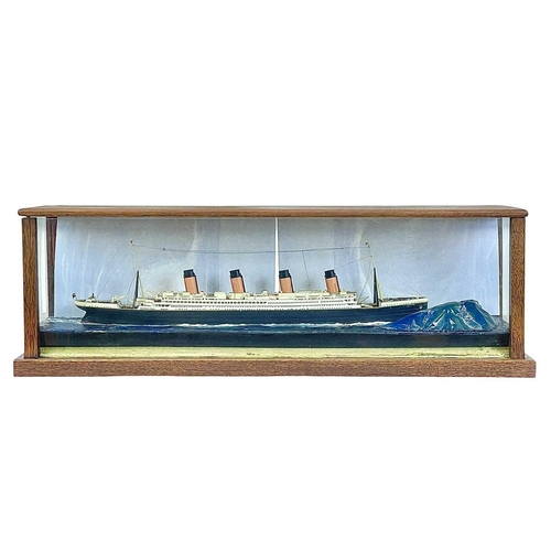 106 - A model of the Titanic. The glazed mahogany case incorporates an iceberg, overall length 65.5cm.