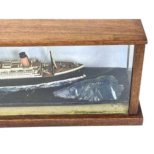 106 - A model of the Titanic. The glazed mahogany case incorporates an iceberg, overall length 65.5cm.