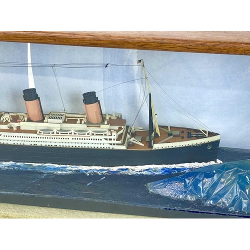 106 - A model of the Titanic. The glazed mahogany case incorporates an iceberg, overall length 65.5cm.