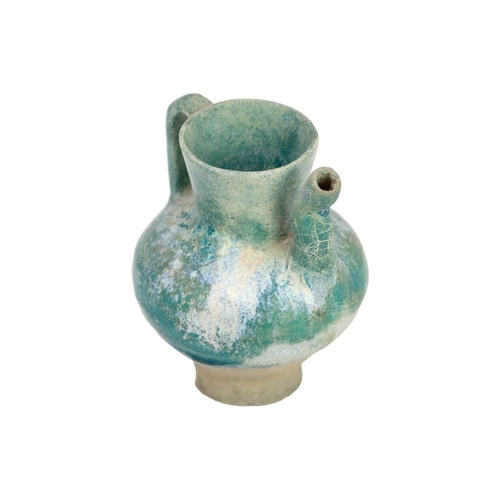 1072 - A Kashan turquoise glaze small spouted pot or ewer. 12th/13th century, with traces of silver lustre,... 