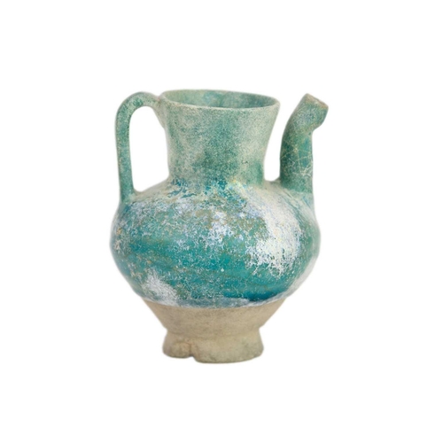 1072 - A Kashan turquoise glaze small spouted pot or ewer. 12th/13th century, with traces of silver lustre,... 