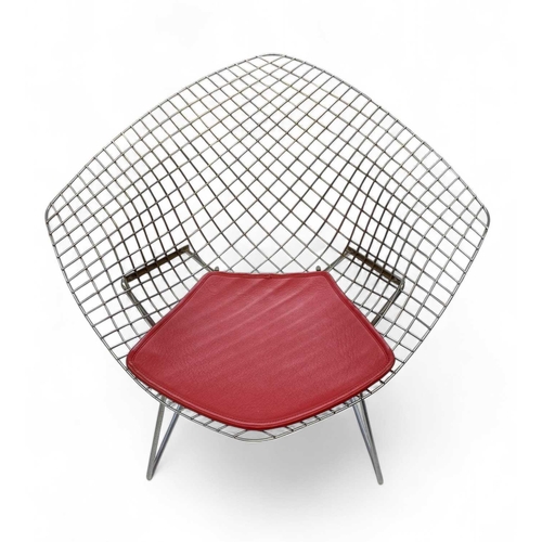 1092 - After Harry Bertoia a pair of 'Diamond' armchairs. Modern, of wire mesh construction, with red padde... 