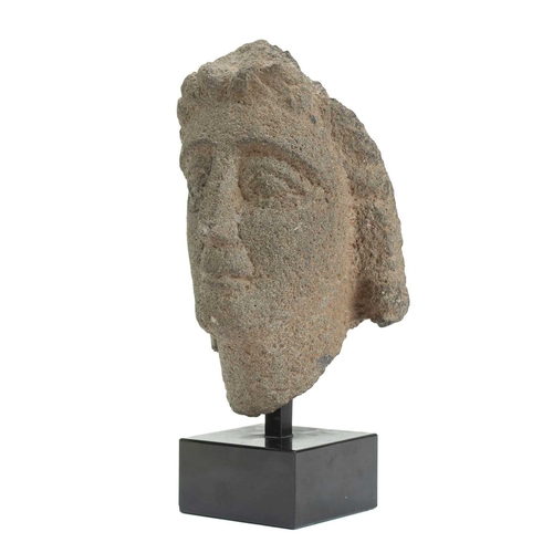 1111 - A Gallo-Roman carved stone head. 1st-3rd century AD, with almond shape eyes, and a 'Gioconda smile',... 