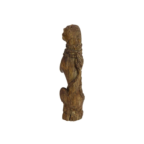 1130 - An oak 'Kings Beast' carved figure. Tudor, circa 1530, wearing a studded collar and with the tail cu... 