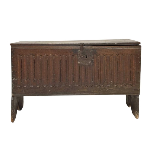 1142 - A 17th century oak plank coffer. The front panel with carved nulling, on shaped end supports, height... 