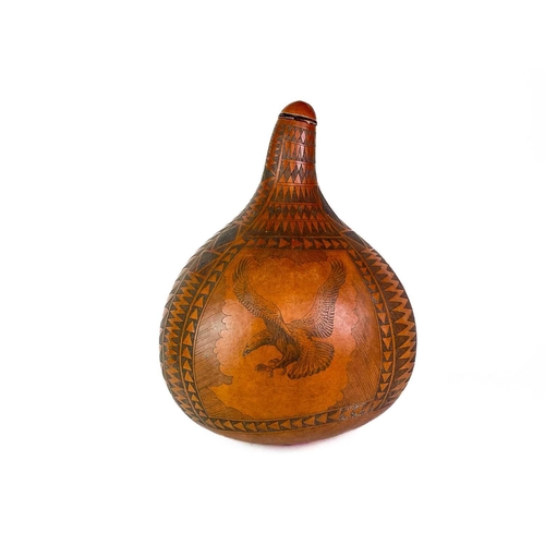 15 - A large carved gourd. Decorated with an African buffalo and an eagle bordered with geometric designs... 