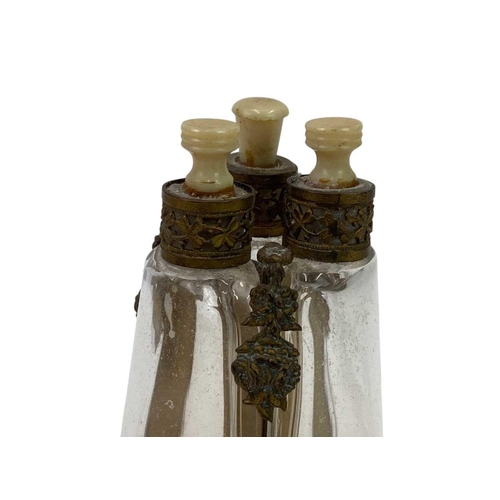 150 - A French brass triple glass scent bottle. With ivorine stoppers, height 12.5cm.