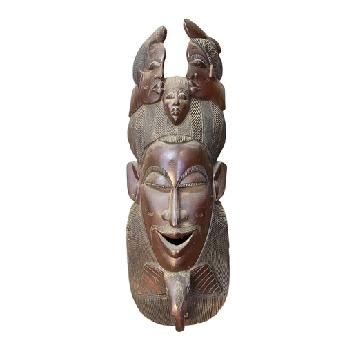 164 - A large African carved mask. Height 67cm together with another larger African mask. (2)