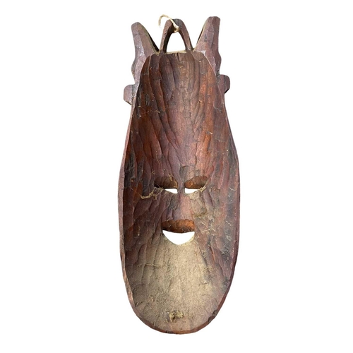 164 - A large African carved mask. Height 67cm together with another larger African mask. (2)