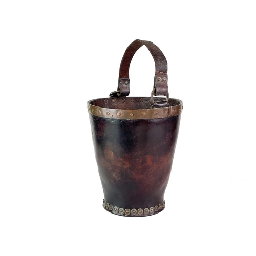 23 - A leather and copper bound riveted fire bucket. With leather handle strap, height 30cm.