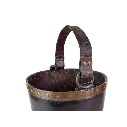 23 - A leather and copper bound riveted fire bucket. With leather handle strap, height 30cm.