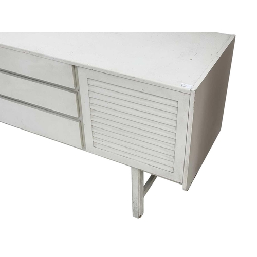 303 - An A H Mcintosh mid-century white finish sideboard. With three louvre effect doors, and three drawer... 