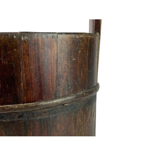 36 - A coopered well bucket. With overhead handle and iron bands, height 49cm.