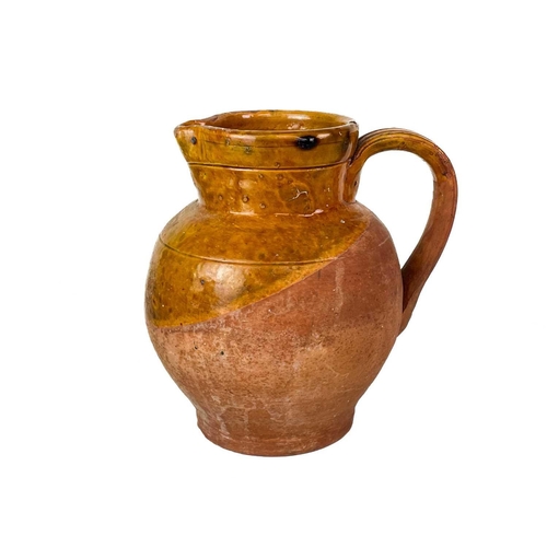 413 - A Muchelney Pottery jug. Impressed marks, height 20cm, together with a Muchelney Pottery jar and cov... 