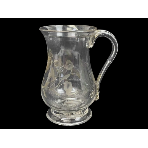 415 - A George III baluster glass small mug. With a folded rim, loop handle, and floral engraved decoratio... 