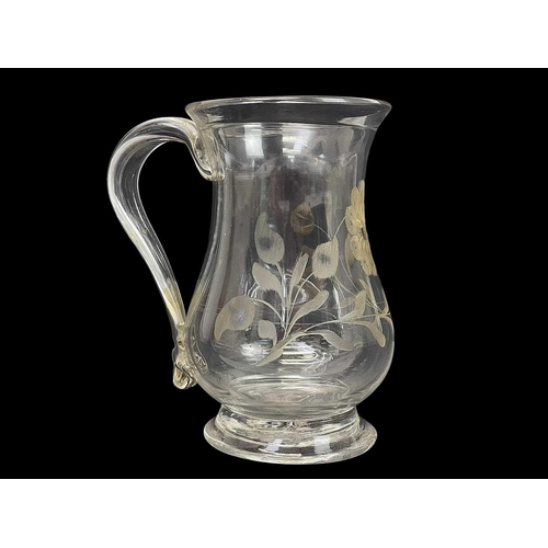 415 - A George III baluster glass small mug. With a folded rim, loop handle, and floral engraved decoratio... 