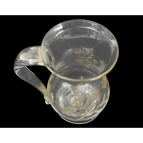 415 - A George III baluster glass small mug. With a folded rim, loop handle, and floral engraved decoratio... 