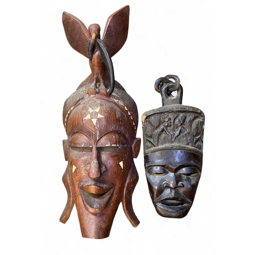 44 - A large African carved mask. Inlaid with bone, height 93cm together with another African carved mask... 