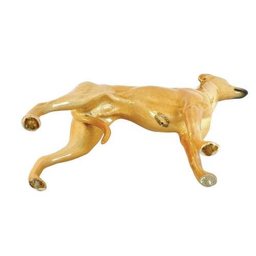 465 - A Beswick figure of a whippet. With curled tail, height 12cm.