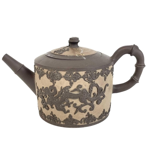 473 - An English dry-bodied stoneware teapot and cover. Circa 1760, applied in brown with two dragons with... 