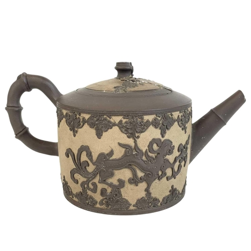 473 - An English dry-bodied stoneware teapot and cover. Circa 1760, applied in brown with two dragons with... 