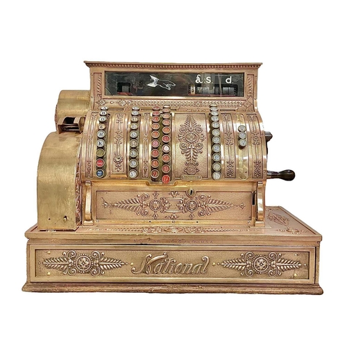 50 - A polished brass National cash register. Circa 1900, with ornate cast and pierced decoration, with c... 