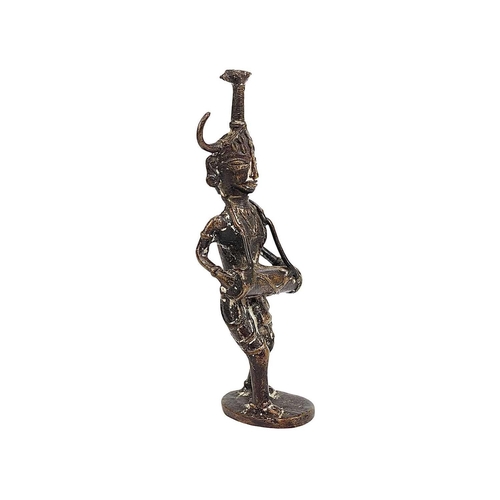 53 - An Indian cast bronze figure of a musician. Dhokra, West Bengal, the figure with a horned headpiece,... 