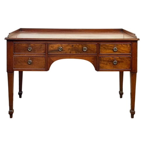 704 - A late George III mahogany galleried side table. Fitted with an arrangement of four drawers, on squa... 