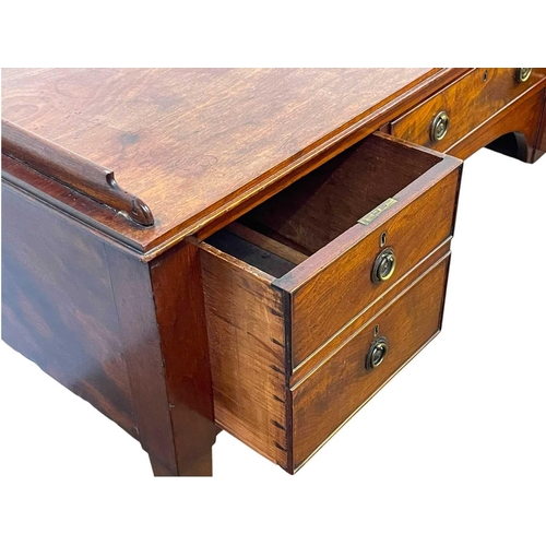 704 - A late George III mahogany galleried side table. Fitted with an arrangement of four drawers, on squa... 