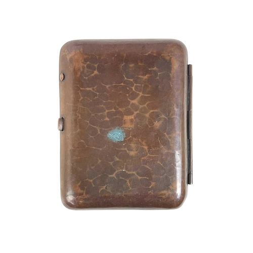 80 - A Newlyn copper and enamel cigarette case. With a planished finish and central blue enamel boss, sta... 