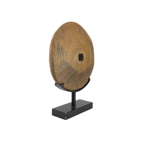 9 - An Eastern hardwood wheel. Mounted as a disc form sculpture, diameter 44cm, overall height 63cm.