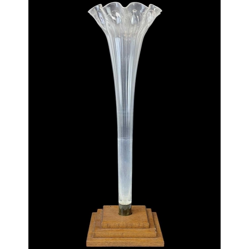 90 - A large glass trumpet vase. Mounted on a stepped oak square base, height 76cm together with a bisque... 