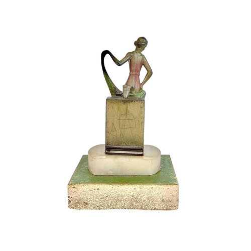 97 - An Art Deco spelter strike table lighter. Modelled as a fashionable lady, with a coloured dress and ... 