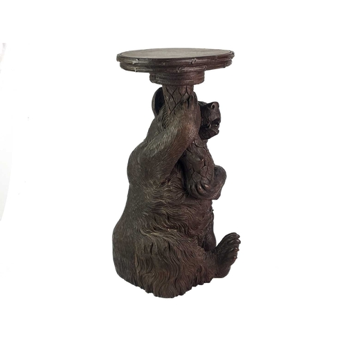 1 - A Black Forest Linden wood carved bear stand. 19th century, with inset glass eyes and supporting a t... 